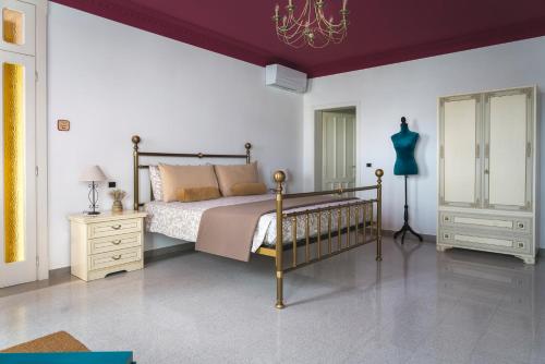 a bedroom with a bed and a chandelier at B&B Villa Ebe in Santarcangelo di Romagna