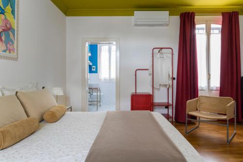a bedroom with a large white bed and red curtains at B&B Villa Ebe in Santarcangelo di Romagna