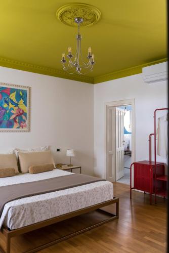 a bedroom with a bed and a chandelier at B&B Villa Ebe in Santarcangelo di Romagna