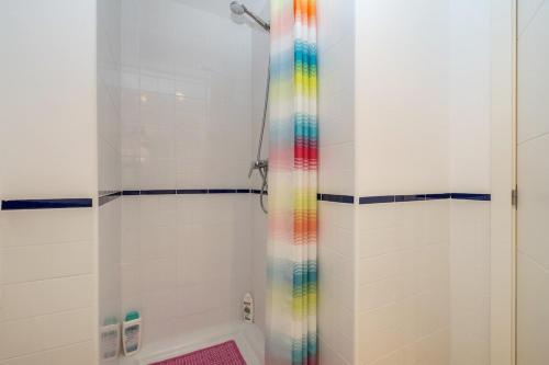 a bathroom with a shower with a rainbow shower curtain at El Bosque in Orihuela Costa