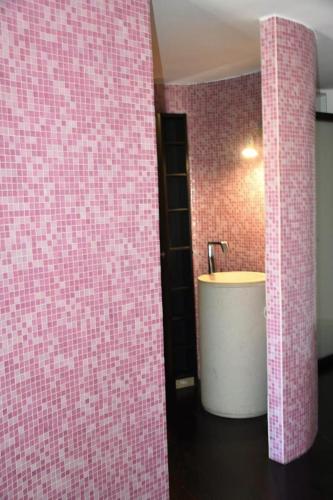 a bathroom with a sink and pink tiled walls at Le Suite Guarinelli B&B in Gaeta