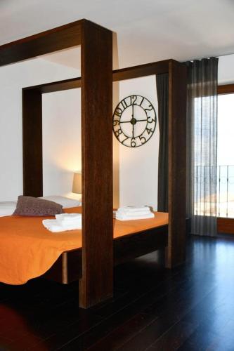 a bedroom with a bed with a clock on the wall at Le Suite Guarinelli B&B in Gaeta