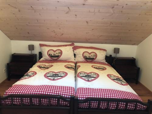 a bedroom with a bed with heart pillows on it at Chalet Schwendli in Schwarzsee