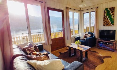 a living room with a couch and a table at Langahlid Cottages & Hot Tubs in Seyðisfjörður