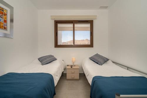 2 camas individuales en una habitación con ventana en Piña, en San Juan de los Terreros