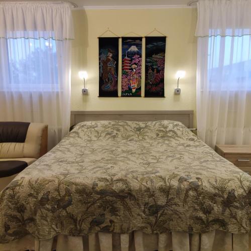 a bedroom with a bed and two windows at Oasis Apartments in Pärnu