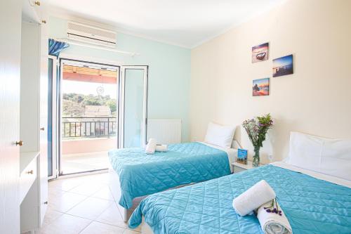 two beds in a room with a balcony at Teta's house sea view in Marathias
