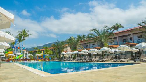 a pool at a resort with chairs and umbrellas at Beach Hotel Maresias in Maresias