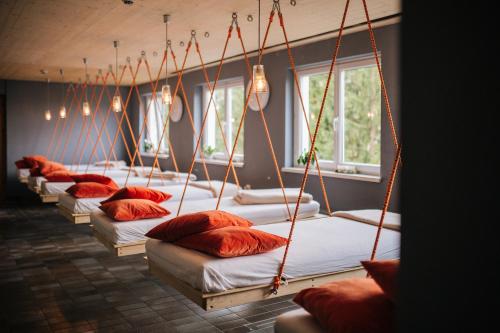 - une rangée de lits avec des oreillers rouges dans l'établissement Design Hotel Miramonte, à Bad Gastein