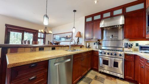 a large kitchen with wooden cabinets and stainless steel appliances at Juniper Crest #24 townhouse in Mammoth Lakes