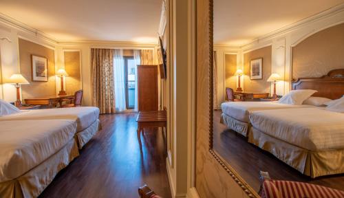 a hotel room with two beds and two lamps at Hotel Sevilla Center in Seville
