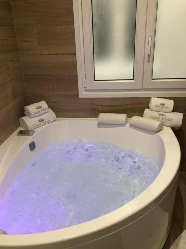 a bath tub filled with blue water in a bathroom at Luxury Apartment with Jacuzzi in Santiago de Compostela