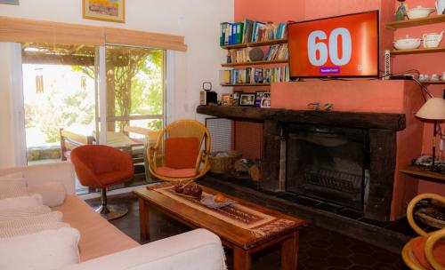 uma sala de estar com televisão e lareira em Finca del Rio - Casa de campo em Tunuyán