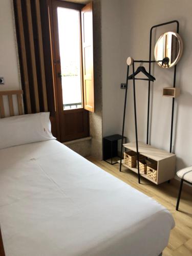 1 dormitorio con cama, lámpara y ventana en Luxury Apartment with Jacuzzi, en Santiago de Compostela