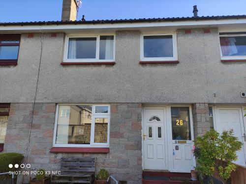 a brick house with a white door and windows at 3-Bed House Sleeps 5 5 min walk from City Centre in Inverness