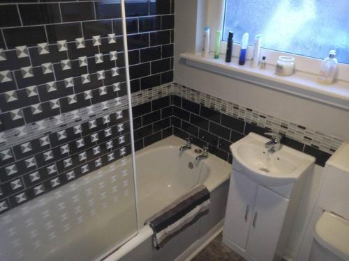3-Bed House 5 minute walk from Inverness Centre في إينفيرنيس: حمام مع حوض ومغسلة ومرحاض