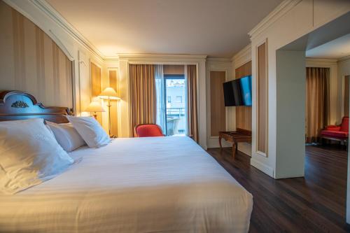 a hotel room with a large bed and a television at Hotel Sevilla Center in Seville