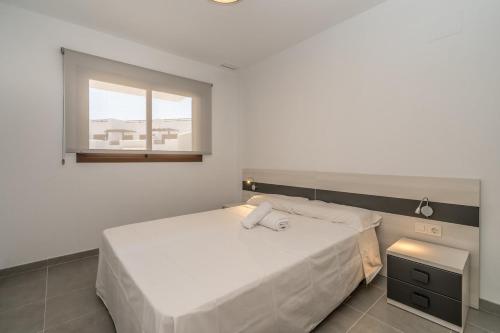 Un dormitorio con una gran cama blanca y una ventana en Pasas, en San Juan de los Terreros