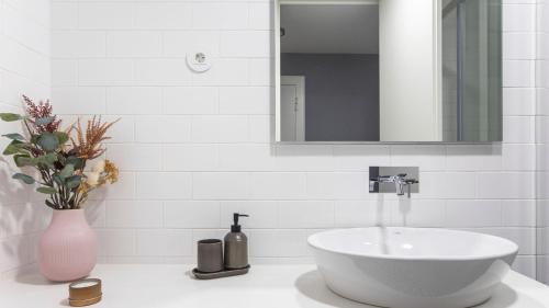 bagno con lavandino bianco e specchio di Stylish Studio w/ AC & Balcony by LovelyStay a Porto