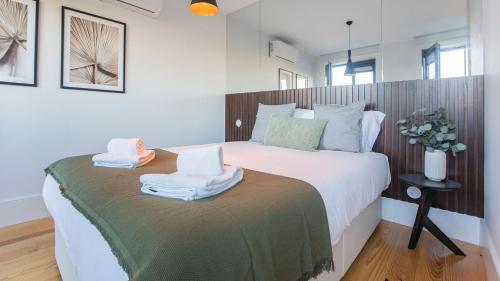 una camera da letto con un grande letto con asciugamani di Stylish Studio w/ AC & Balcony by LovelyStay a Porto