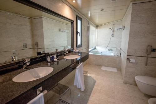 a bathroom with two sinks and a tub at Hotel Sevilla Center in Seville