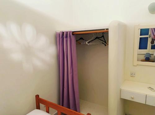 a bathroom with a purple curtain and a sink at Vitamin Sea Protaras in Protaras