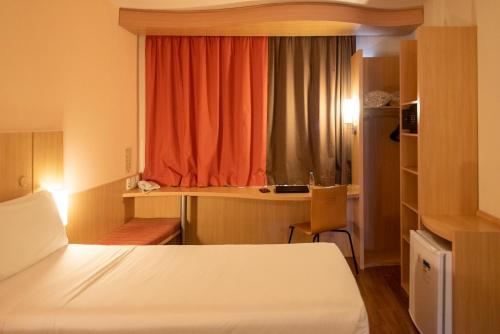 a room with a bed and a window and a desk at ibis Sao Paulo Barra Funda in Sao Paulo