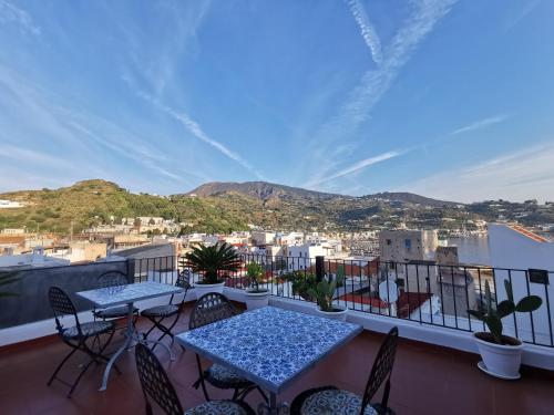 balcone con tavoli, sedie e vista sulla città di Lo Nardo Accommodation a Città di Lipari