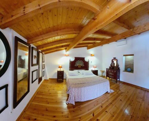 a bedroom with a large bed and wooden ceilings at Casas De Romaria in Brotas