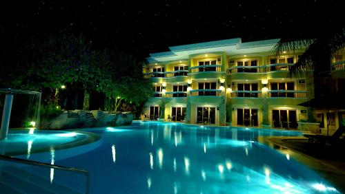 a swimming pool in front of a hotel at night at Henann Regency Resort and Spa in Boracay