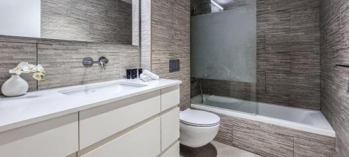 a bathroom with a sink and a toilet and a tub at BnBIsrael apartments - HaYarkon Orchide in Tel Aviv