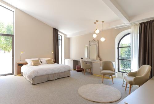 una camera da letto con un letto, una scrivania e delle sedie di Domaine de la Galinière a Châteauneuf-le-Rouge