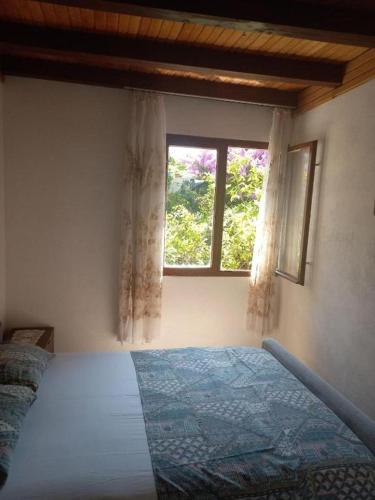 a bedroom with a bed and a window at Beach Island House in Korčula