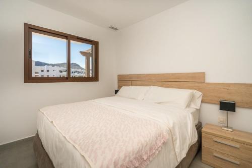 - une chambre avec un grand lit et une fenêtre dans l'établissement Verde, à San Juan de los Terreros