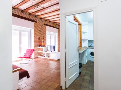 an open door to a kitchen with a red chair at Total Valencia Charming in Valencia