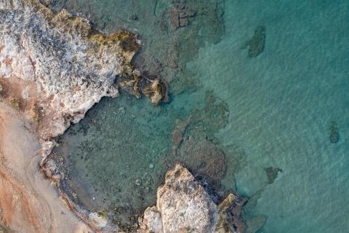 una vista aérea del océano y de una costa rocosa en Zen Luxury Villas & Suites, By ThinkVilla en Hersonissos