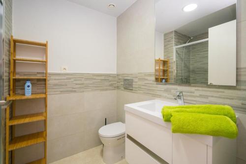 La salle de bains est pourvue d'un lavabo blanc et d'une serviette verte. dans l'établissement Apartment Pomelo, à San Juan de los Terreros