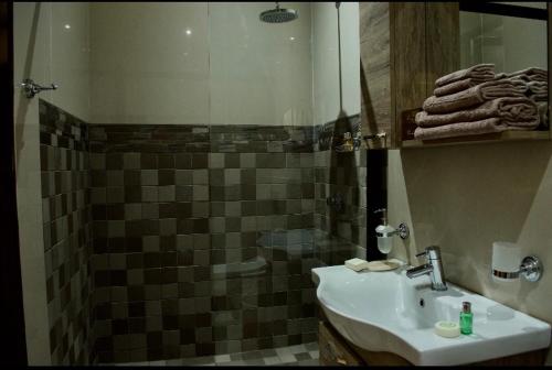 a bathroom with a sink and a shower at Masawara Urban Retreat in Harare