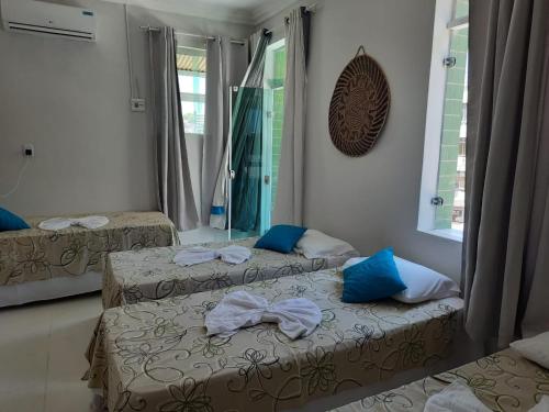 two beds in a room with a mirror at Pousada Corais da Barra in Salvador