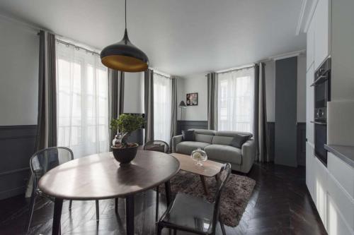 a living room with a table and a couch at Black Pearl in Paris