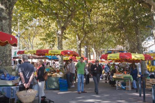 a group of people walking around an outdoor market at La Victoire Boutique Hotel in Vence