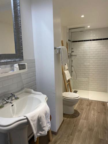 a bathroom with a sink and a toilet at The Originals Boutique, Hôtel La Colonne de Bronze, Saint-Valéry-sur-Somme in Saint-Valery-sur-Somme