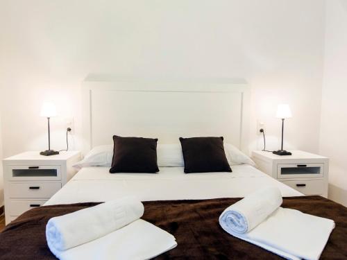 1 dormitorio blanco con 1 cama blanca grande y 2 mesitas de noche en Total Valencia Charming, en Valencia