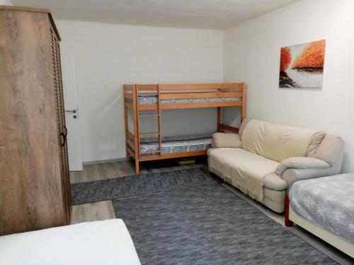 - une chambre avec un canapé et des lits superposés dans l'établissement Apartment Azra - Sarajevo, Ilidza, à Sarajevo