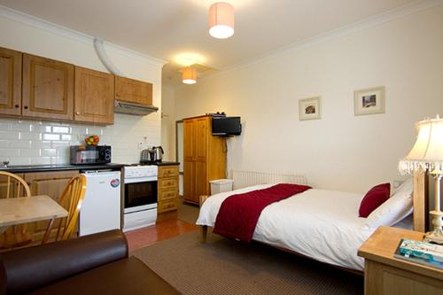 a bedroom with a bed and a kitchen with a kitchen at Glencourt Apartments in Dublin