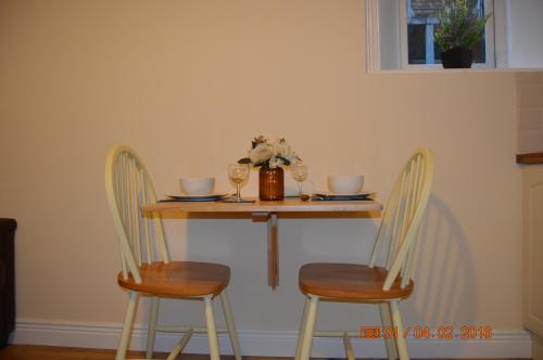 a table with two chairs and a table with wine glasses at Glencourt Apartments in Dublin
