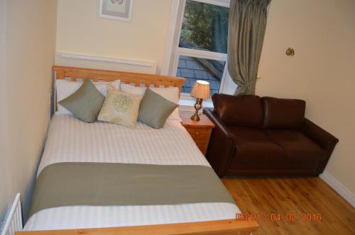 a bedroom with a bed and a leather chair at Glencourt Apartments in Dublin
