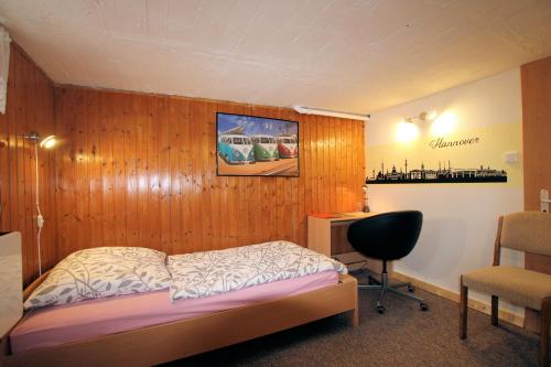 a bedroom with a wooden wall with a bed and a desk at ABT - Private Room for 1 in Hannover