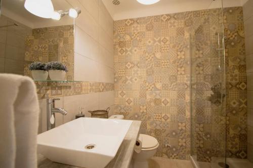 a bathroom with a sink and a toilet and a shower at Hotel Carina in Apt