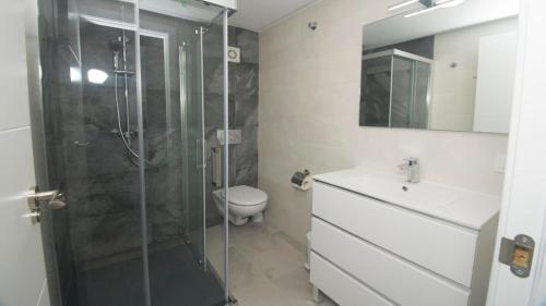 ein Bad mit einer Dusche, einem WC und einem Waschbecken in der Unterkunft Turmalina 35c in Calpe